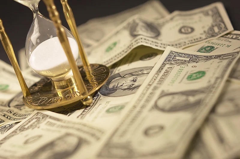 close up of American Currency with an hourglass